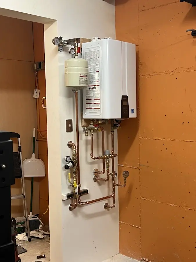 Plumbing technician inspecting water heater connections in Muscle Shoals